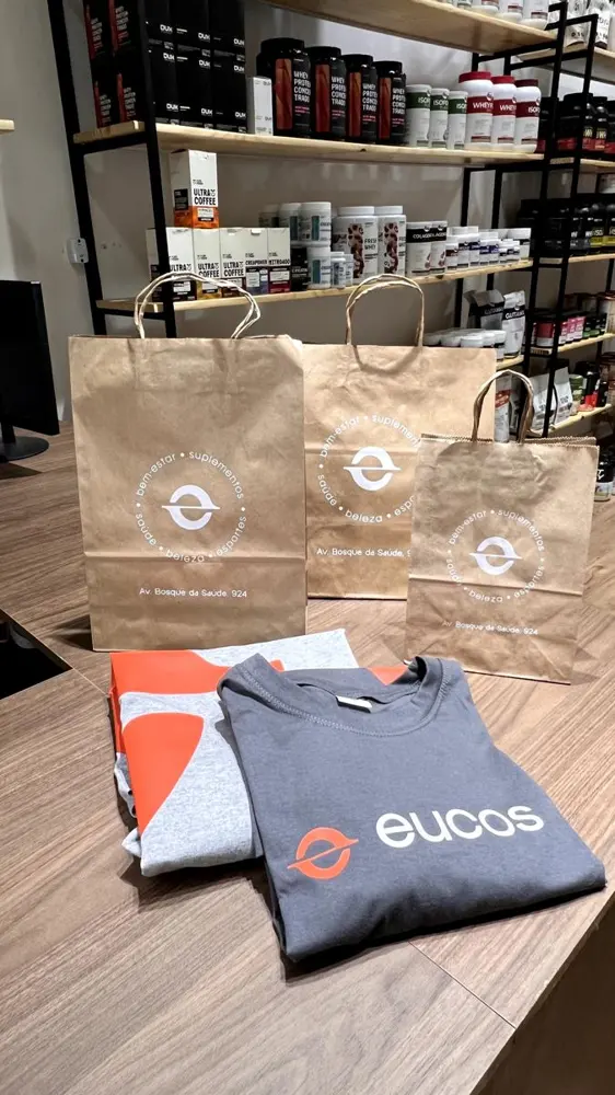 Sacolas e camiseta com a marca Eucos no balcão da loja